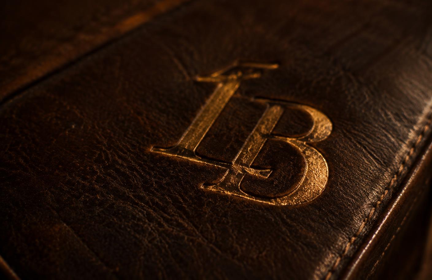 Gold monogram embossed into dark leather